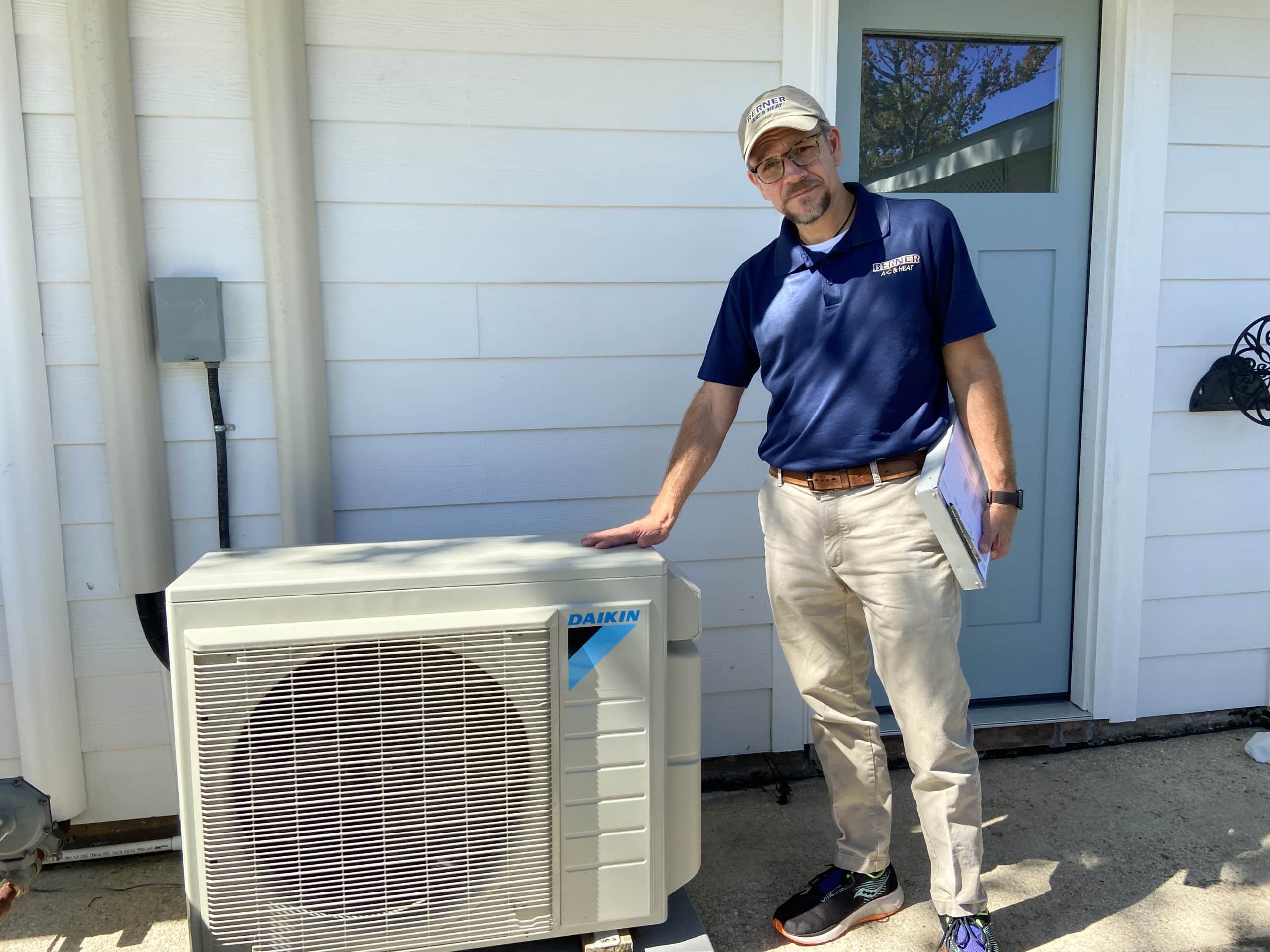 Supervisor inspecting ductless mini-split outdoor unit during installation